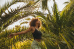 Pretty young afro woman among palm trees